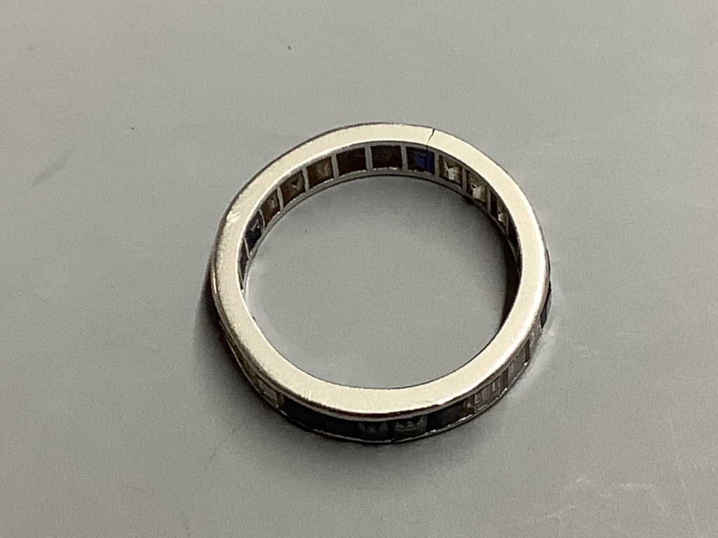 An 18ct white gold calibre-cut diamond and sapphire eternity ring